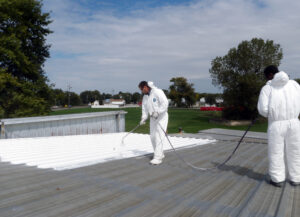 A Jewett Roofing crew spraying on a new commercial roof coating in St. Louis